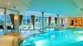 An outdoor swimming pool connected to an indoor heated swimming pool